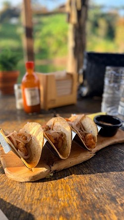 Luxury gastronomy experience in Guatapé, Colombia featuring gourmet tacos at a floating restaurant.